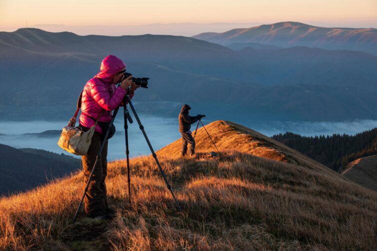 Photographes avec trépieds sur un sommet de montagne observant le paysage