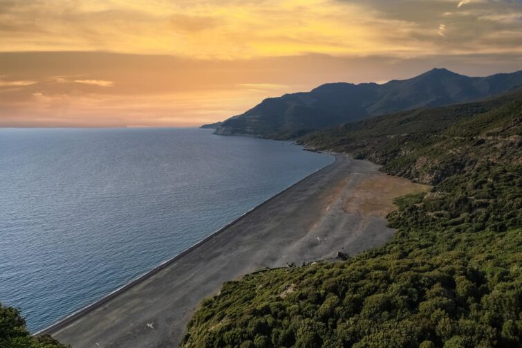 Vue aérienne de la plage de Nonza au Cap Corse avec son sable noir et les eaux turquoise de la Méditerranée