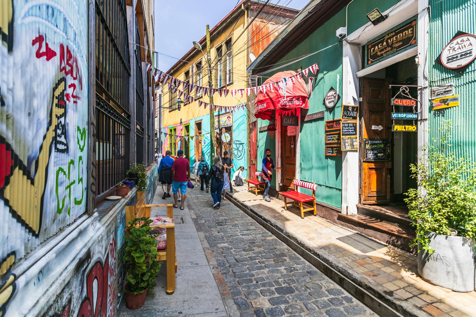 Vue de la rue animée dans le centre historique de Valparaiso, Chili, avec des bâtiments colorés et des graffitis artistiques
