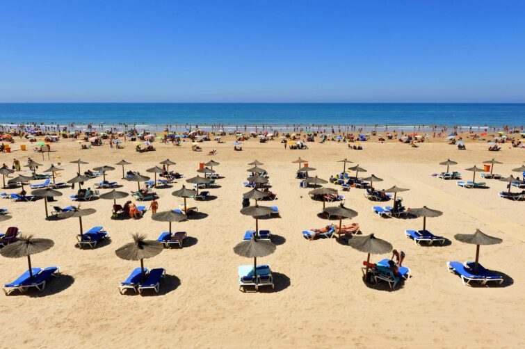 Vue panoramique de Playa de la Victoria à Cádiz avec sable doré et ciel clair