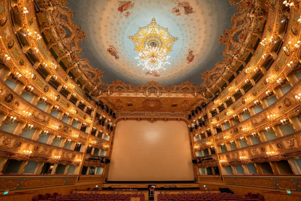 Intérieur de l'opéra Teatro La Fenice à Venise, intérieur de style rococo avec un plafond avec peintures et lustre.