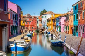 Maisons colorés et bateaux amarrés sur l'eau à Burano, Venise, Italie