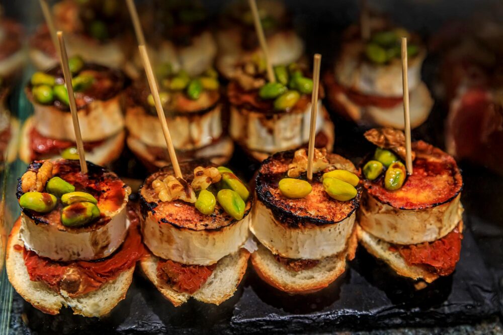 Pintxos espagnols traditionnels avec fromage de chèvre, pistaches, noix et piquillo rouge à San Sebastian