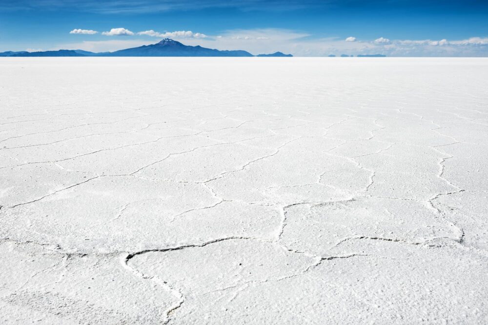 Surface de sel blanc et volcan en arrière-plan au Salar d’Uyuni