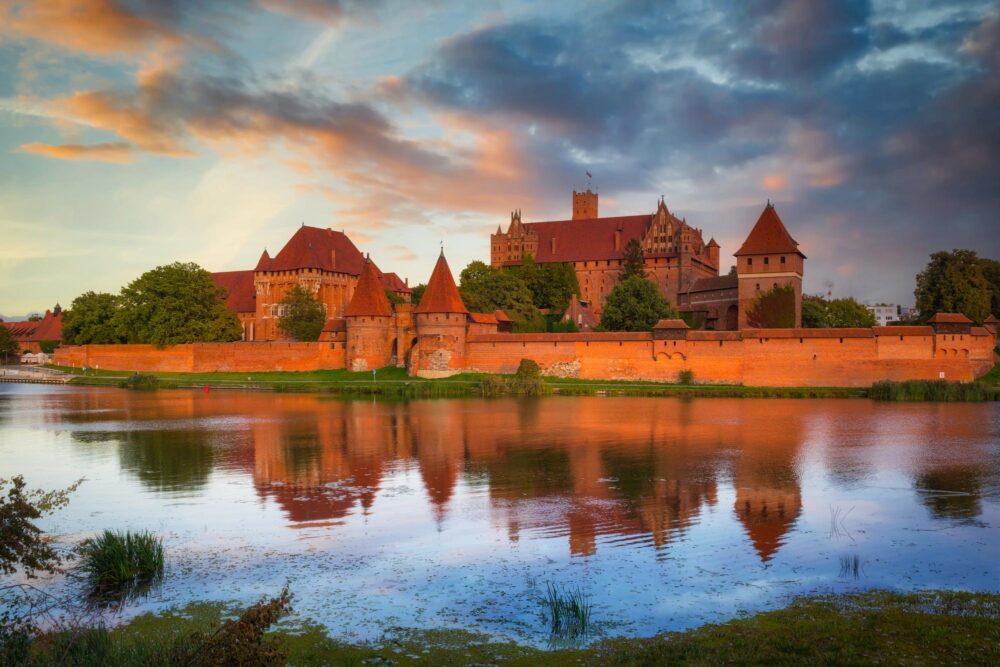 Château de Malbork au-dessus de la rivière Nogat au coucher du soleil, Pologne