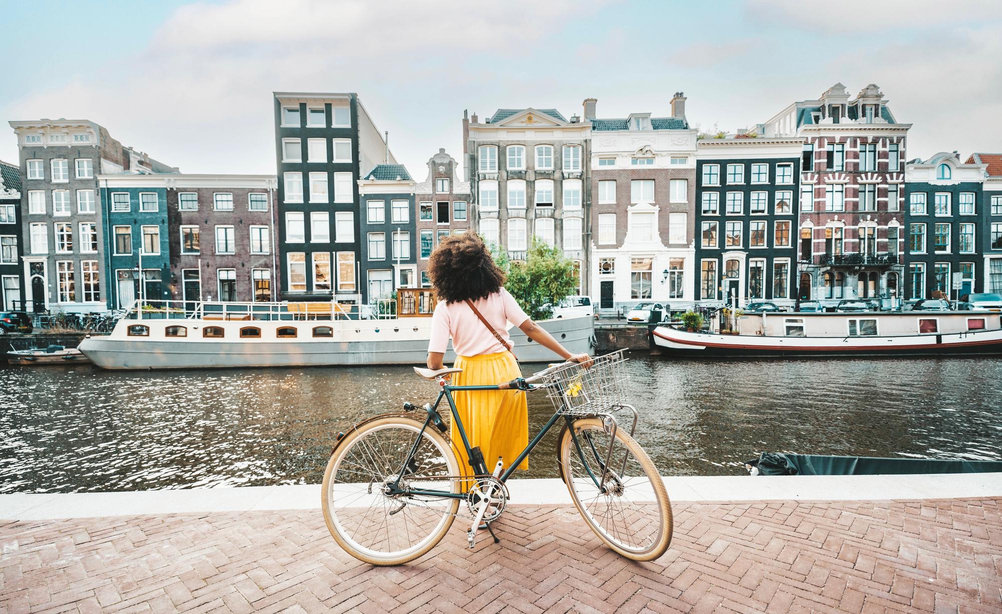 Femme à vélo devant les canaux d'Amsterdam