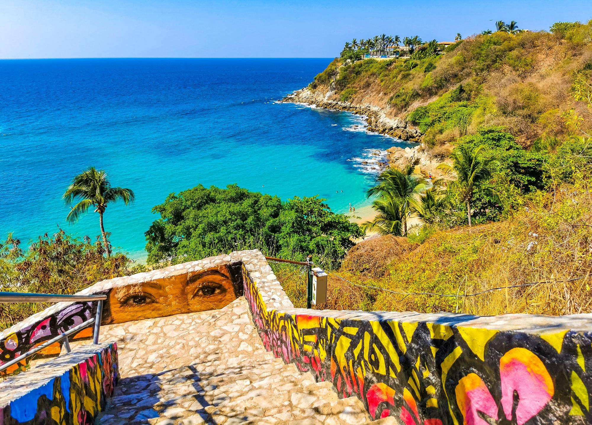 Marches d'escaliers en pierre avec des peintures peintes jusqu'à la plage à l'eau turquoise de Carrizalillo à Puerto Escondido au Mexique