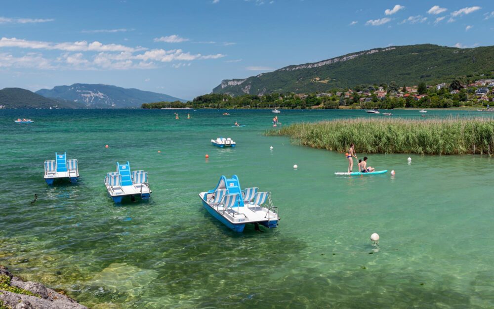 Activités nautiques sur les eaux bleues du lac du Bourget au milieu des montagnes à Aix-les-bains