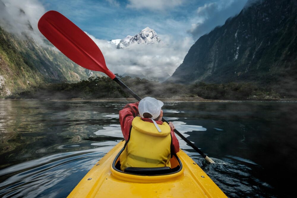Jeune garçon faisant du kayak à Milford Sound, Nouvelle-Zélande