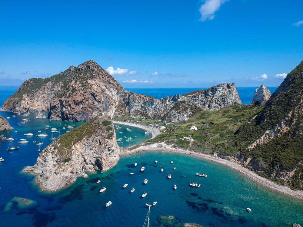 Vue aérienne sur l'île de Palmarola avec eau verte et eaux cristallines et bateaux, îles Pontines, Italie