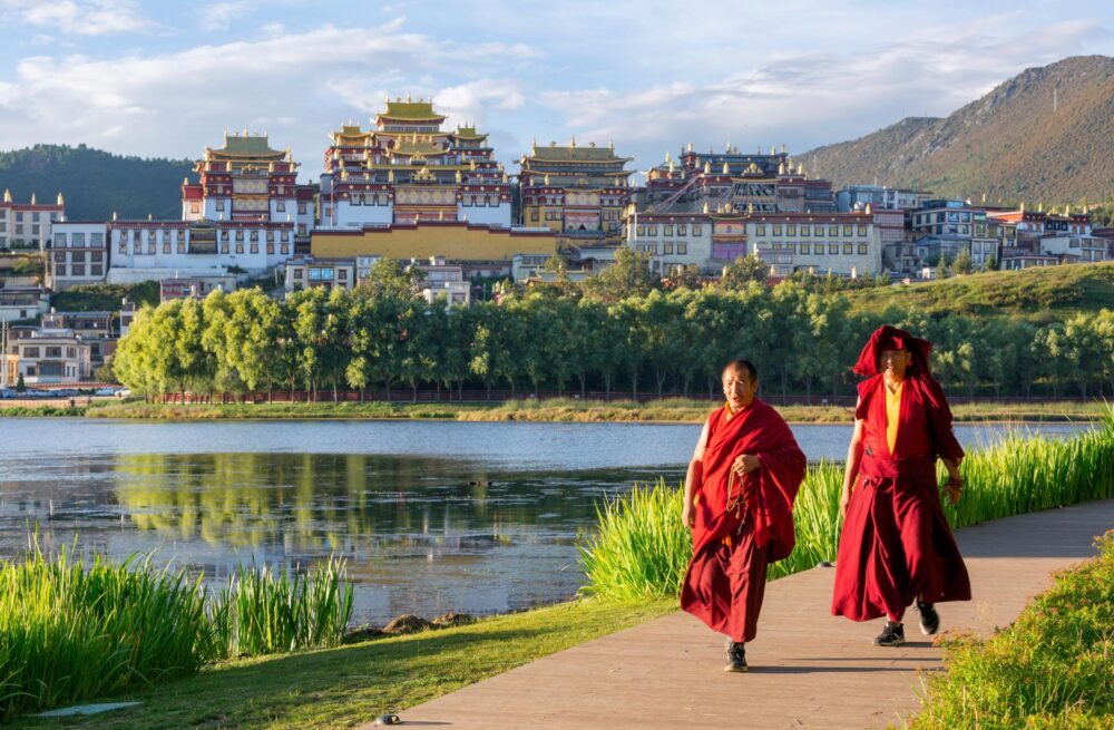 Moines marchant devant le monastère de Ganden au Tibet
