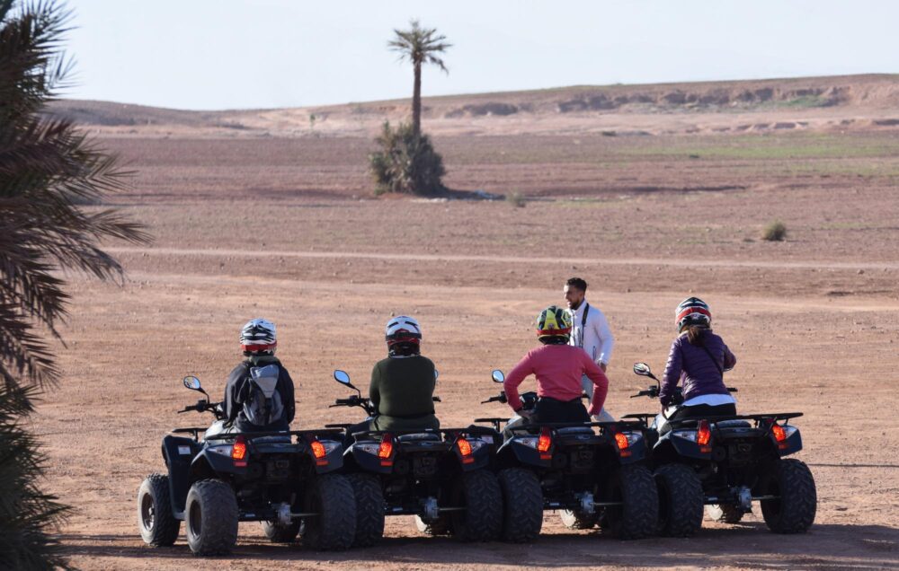 Touristes faisant du quad dans la Palmeraie de Marrakech, Maroc